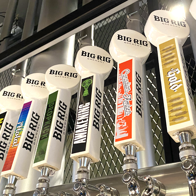Beer tap handles labelled with the Big Rig logo and beer type